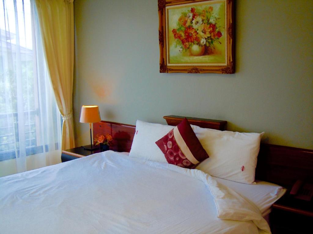 a bedroom with a bed with white sheets and pillows at Moonlight House in Nakhon Ratchasima