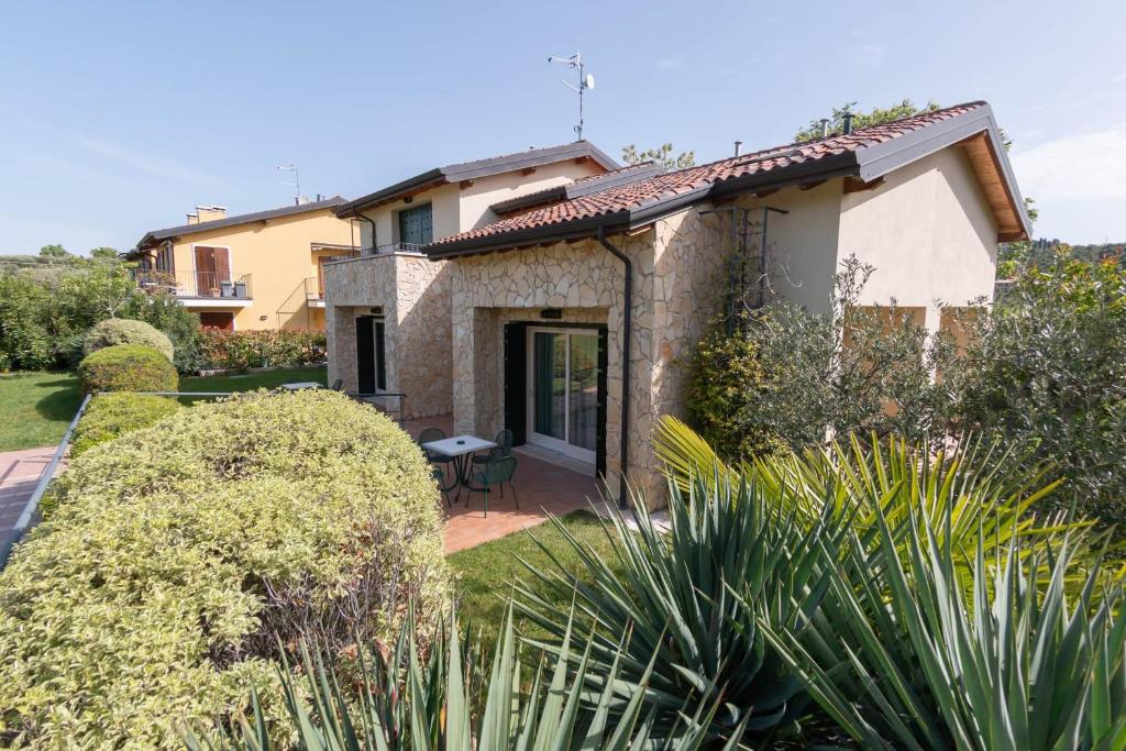 une maison avec un jardin et une terrasse dans l'établissement Vistaverde Harmony Apartments, à Cavaion Veronese