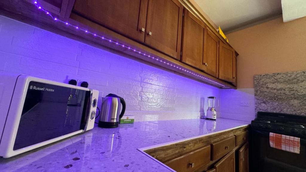 a kitchen with purple lights on a counter top at Multigen-Lip of the City Escape in Castries