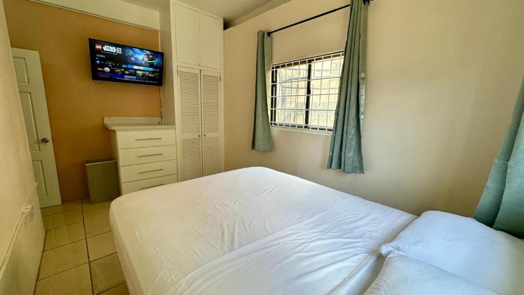 sypialnia z białym łóżkiem i oknem w obiekcie Multigen-Lip of the City Escape w mieście Castries