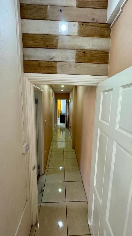 a hallway with a white door and wooden ceilings at Multigen-Lip of the City Escape in Castries