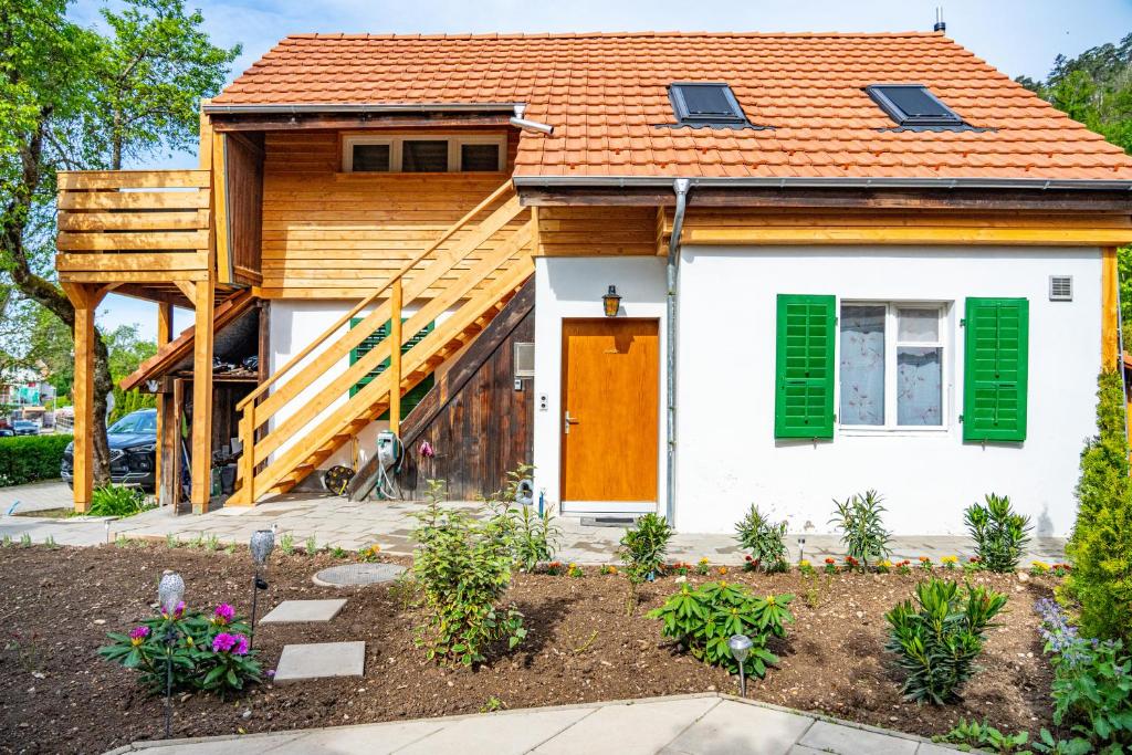 a house with an orange roof and green shutters at Gemütliches Haus mit Terasse und Feuerstelle in Lengnau