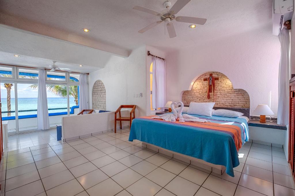 a bedroom with a bed and a view of the ocean at Del Sol Beachfront in Akumal
