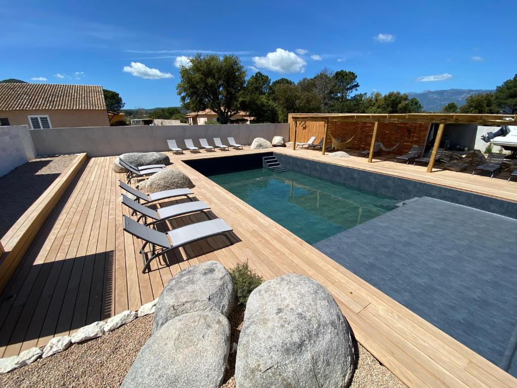 une piscine avec des chaises et une terrasse avec une piscine dans l'établissement Maison neuve Porto Vecchio, à Porto-Vecchio