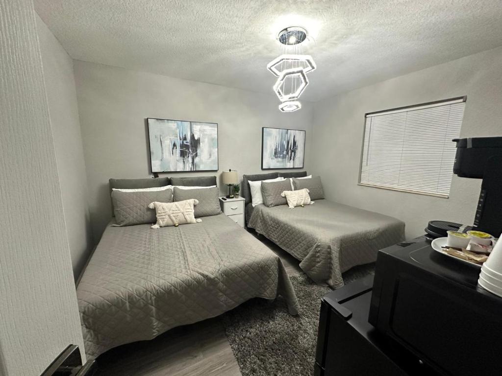 a bedroom with two beds and a chandelier at Awesome in Pembroke Pines