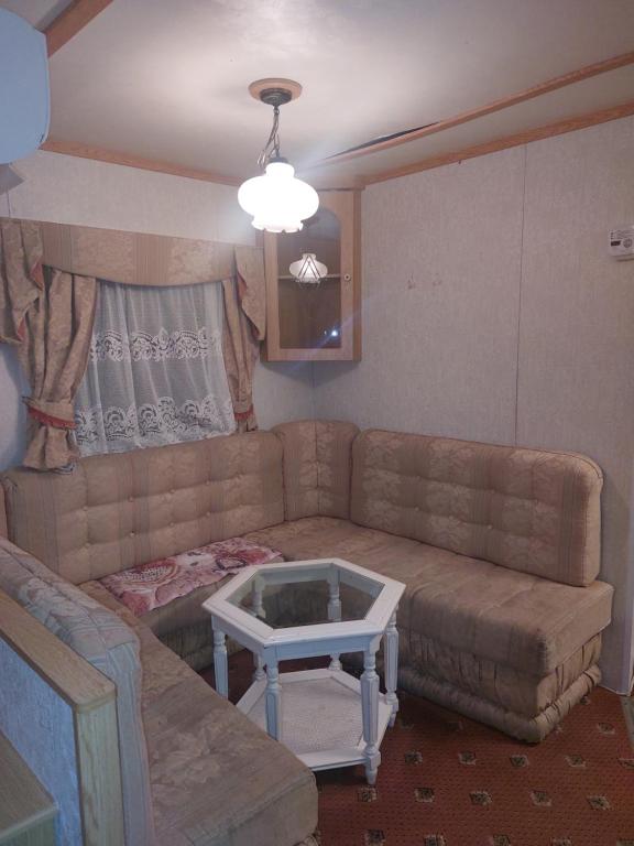 Skurup的住宿－Villavagn på landet östra Skurup，客厅配有沙发和桌子