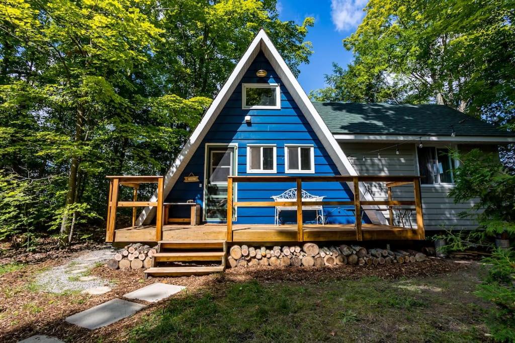 uma pequena casa azul com um telhado de gambrel em A-frame Cottage Lakeside, Charleston lake 