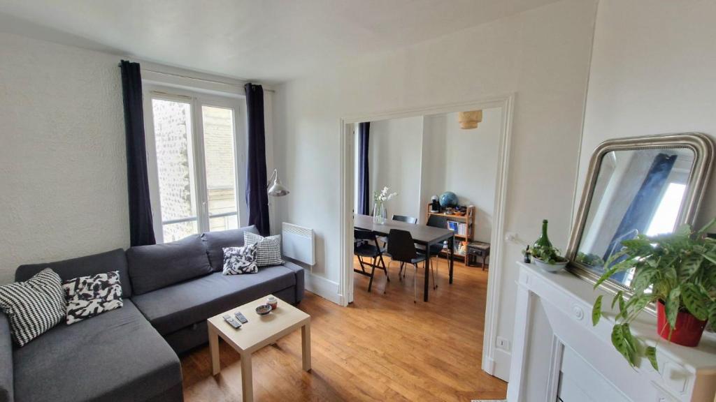 un salon avec un canapé et une table dans l'établissement Beautiful, cosy apartment for 1 to 6 people, located near Olympic Park, à Paris