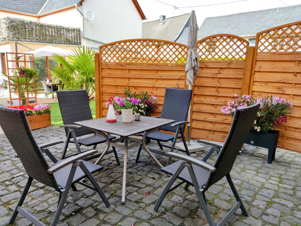 a patio with a table and chairs and a fence at Maifeld-Fewo Rhapsodie in Kerben