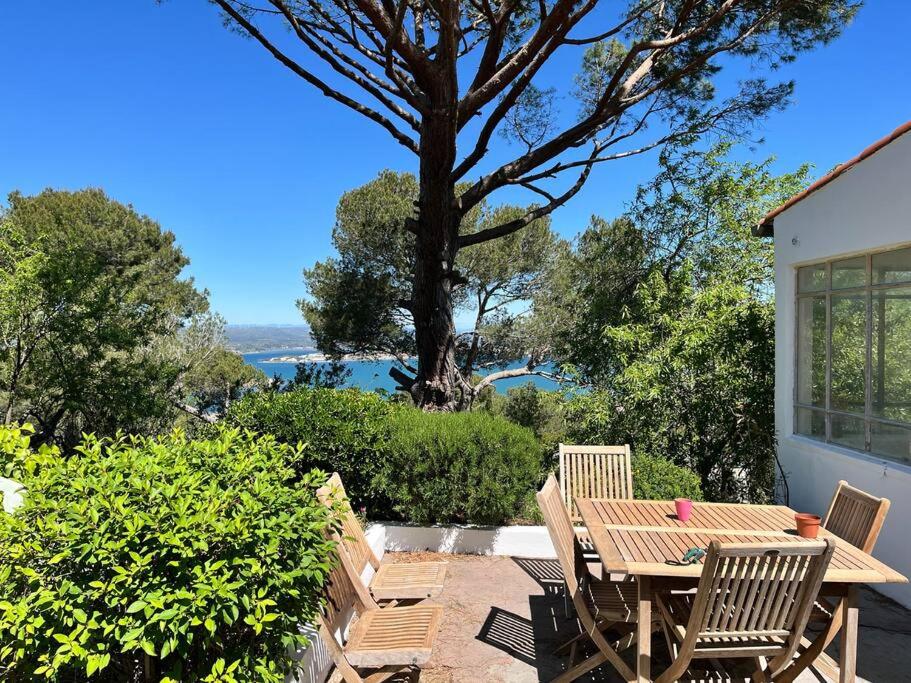 une table et des chaises en bois sur une terrasse avec un arbre dans l'établissement Moun Cantounet, authentique baraquette avec vue imprenable, à Sète