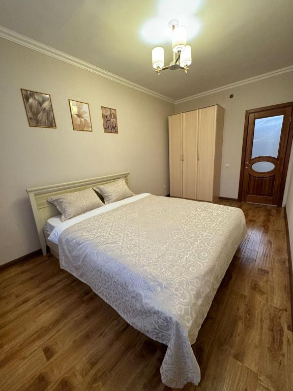 1 dormitorio con 1 cama blanca grande en una habitación en Квартира, en Prigorodnyy