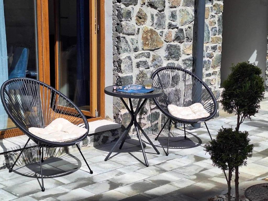 2 sillas y una mesa en el patio en DivčiNova B7 Jovanovic, en Divčibare