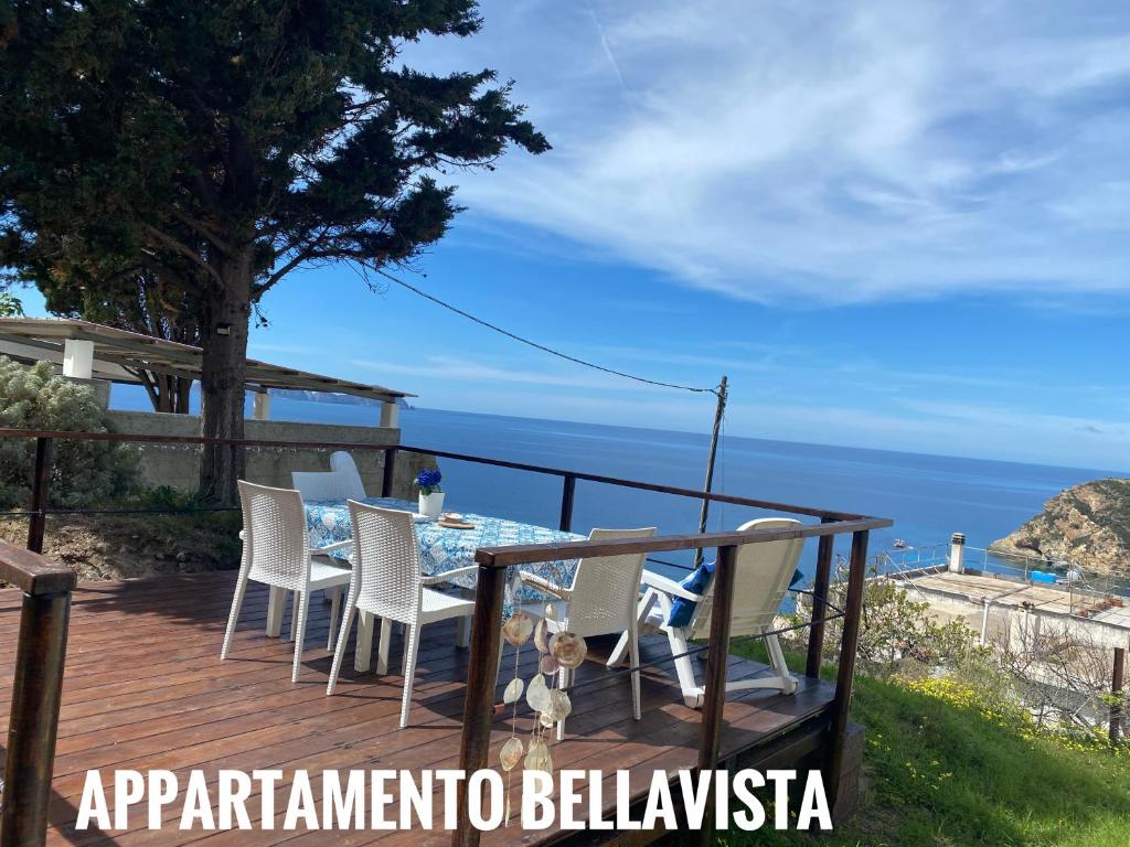 una terraza con mesa, sillas y el océano en Ponzamania Appartamenti Ponza ,,Blumarine'', en Ponza