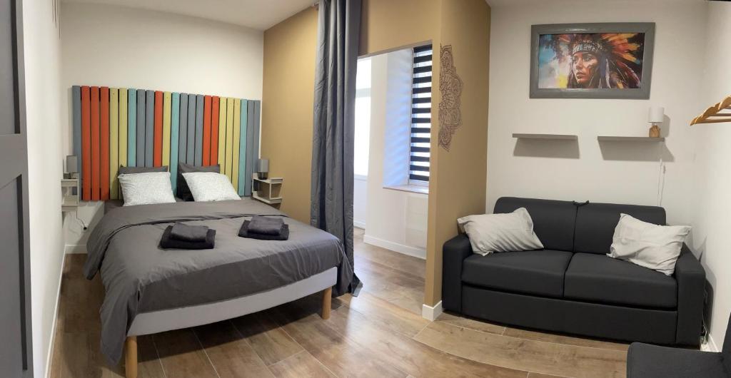 1 dormitorio con 1 cama y 1 sofá en Meublés déco Fab - Plancha en Luxeuil-les-Bains