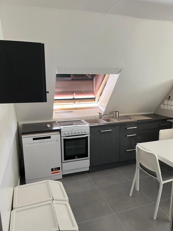 a kitchen with a stove and a sink and a table at Chambre privée 1-2 coatodon in Guipavas