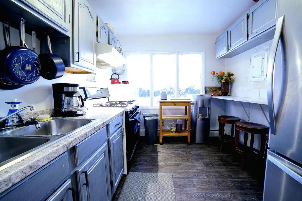 una cocina con armarios azules y fregadero en Compact But Cozy Too en Anchorage