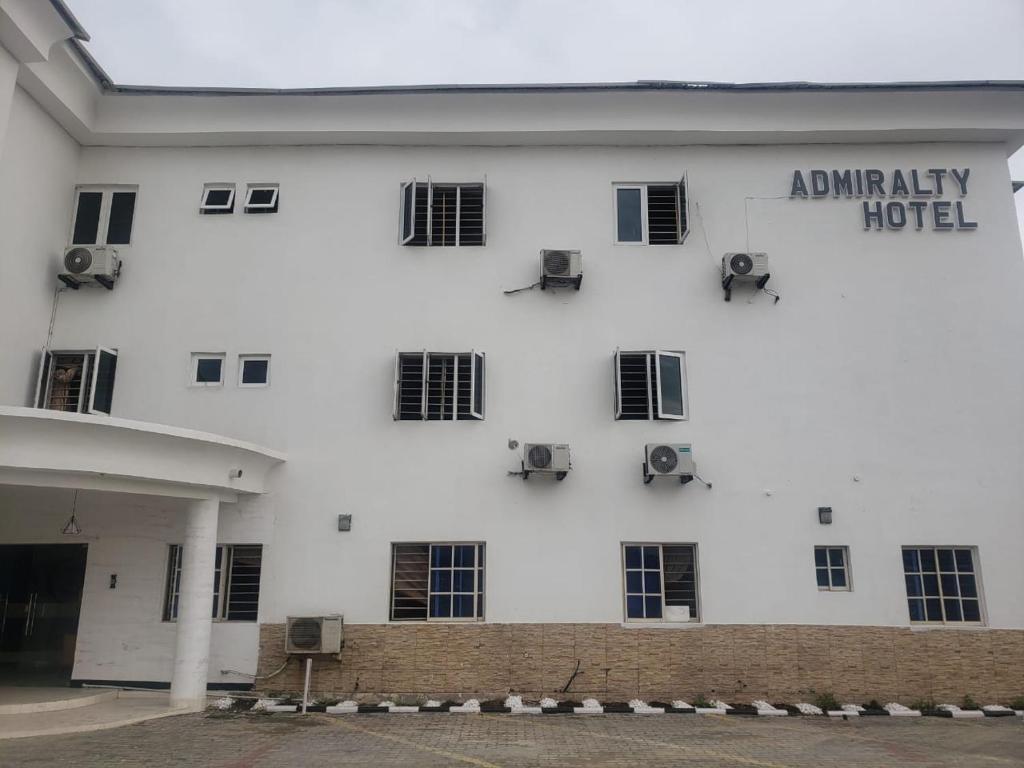a white building with chairs on the side of it at Admiralty Hotel in Lekki