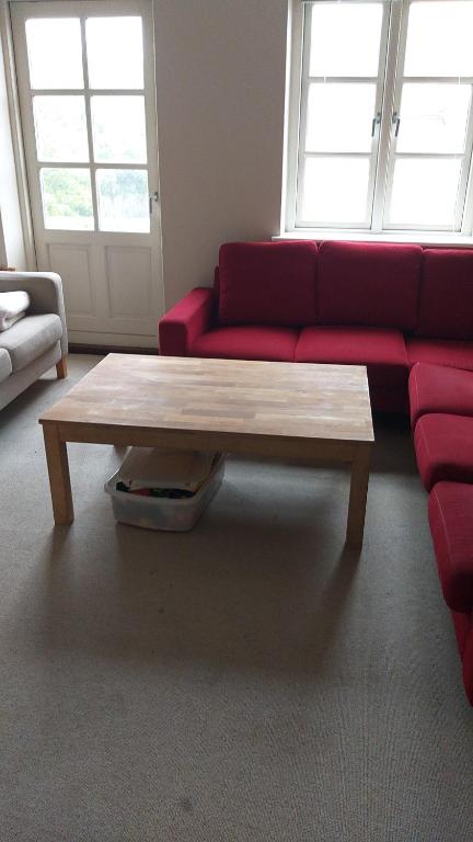 a living room with a red couch and a coffee table at White house 51 in Horsens