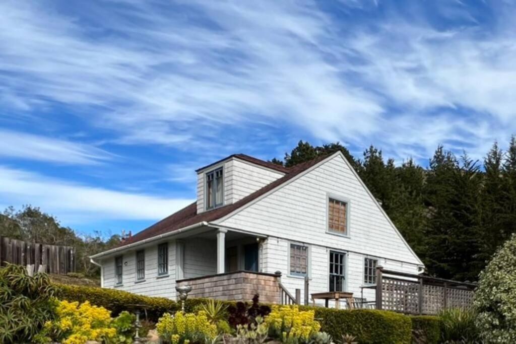 a white house with a fence and trees at Surfmen's Cottage - Historic Coast Guard property in Point Arena