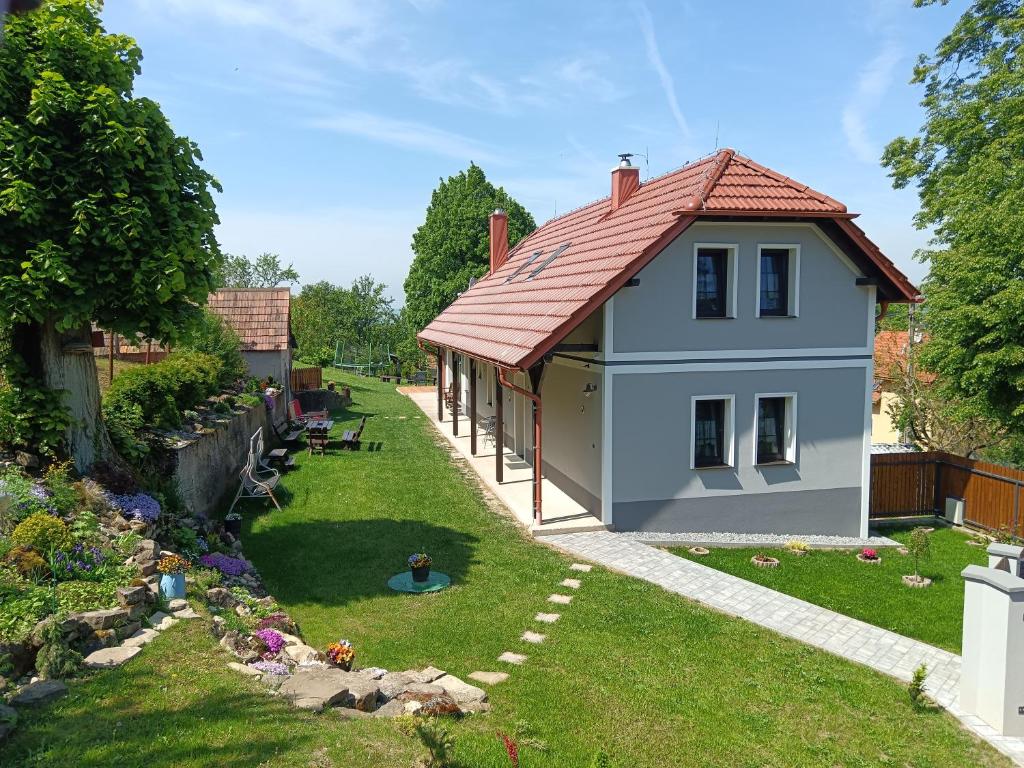 a small house with a red roof in a yard at Chalupa pod hradom Branč in Podbranč