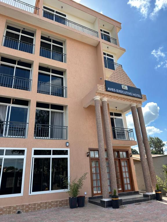 un grand bâtiment avec des piliers devant lui dans l'établissement Aves Executive Hotel, à Arusha