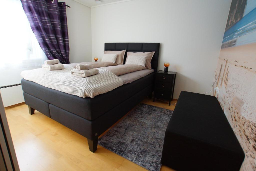 a bedroom with a large bed with towels on it at Cozy room in a house with a garden on the island of Askøy, near Bergen in Askøy