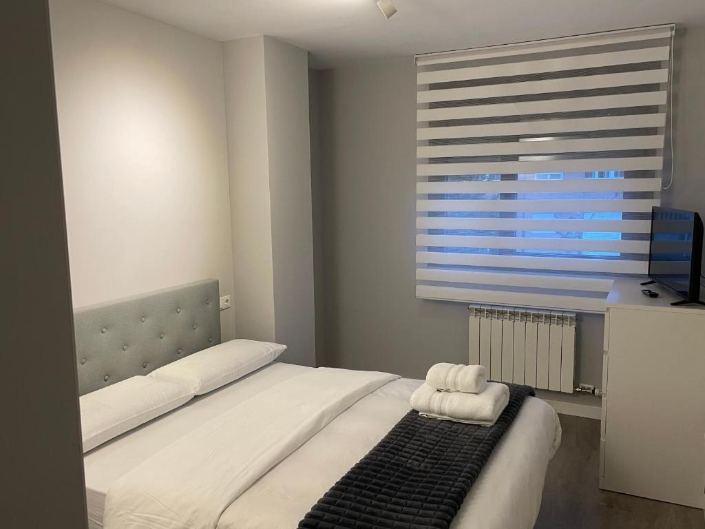 Un dormitorio con una cama con una toalla. en Apartamento Entero 2 HABITACIONES, en León
