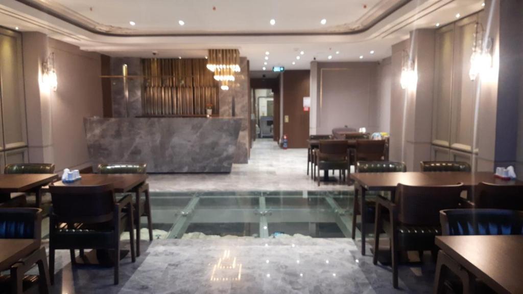 un restaurant avec des tables et des chaises et un sol en verre dans l'établissement Theodosius Hotel, à Istanbul