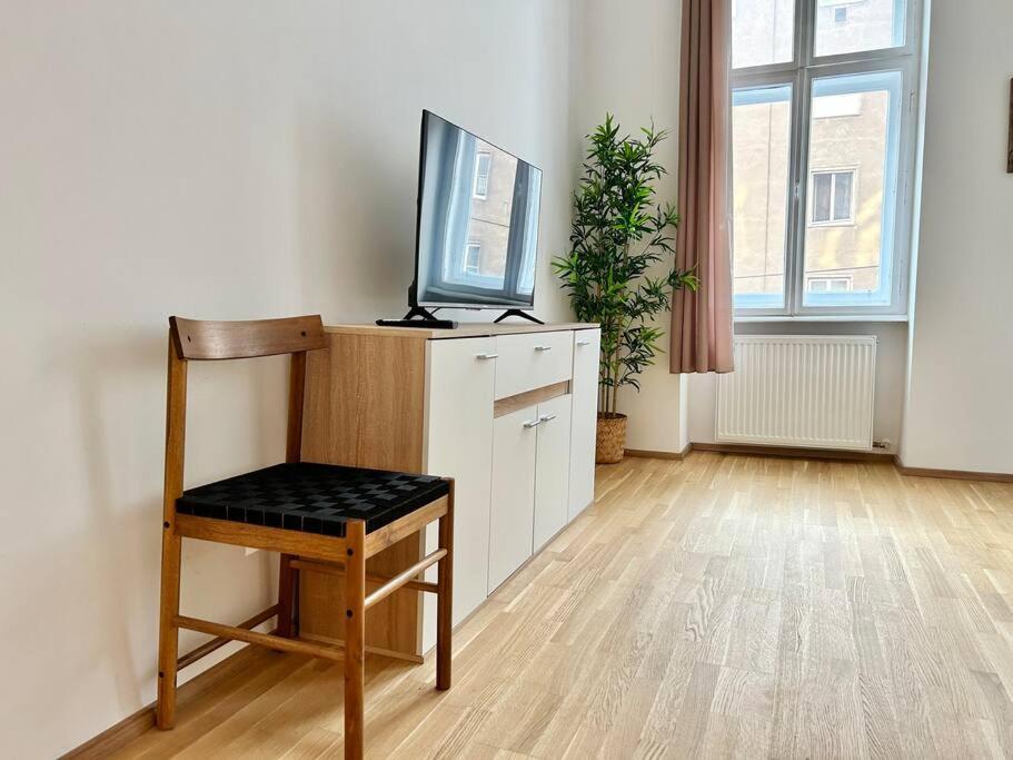 ein Wohnzimmer mit einem TV und einem Stuhl in der Unterkunft Quiet 60 m2 Apartment with Free Parking in Wien