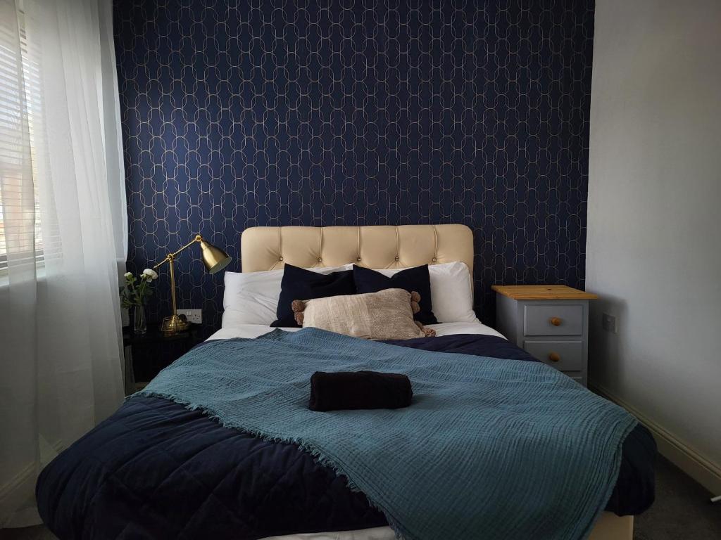 2 Bed Luxury Apartment With 1 FREE Uber Eats Meal في ولفرهامبتون: غرفة نوم مع سرير مع لحاف أزرق