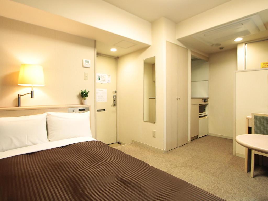 Postel nebo postele na pokoji v ubytování HOTEL LiVEMAX BUDGET Shinbashi