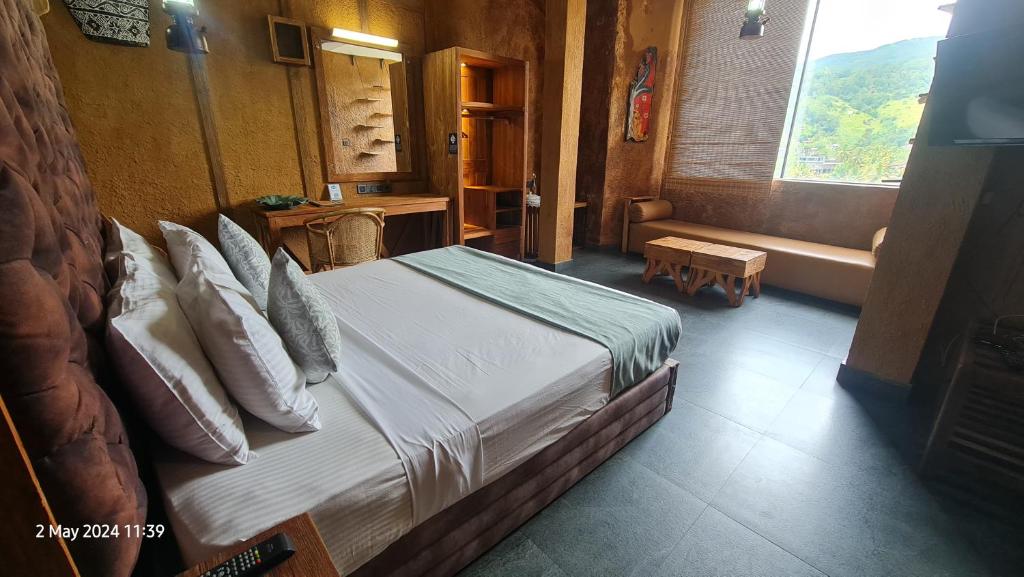 a bedroom with a bed with pillows and a window at Quick Stop Inn in Kandy