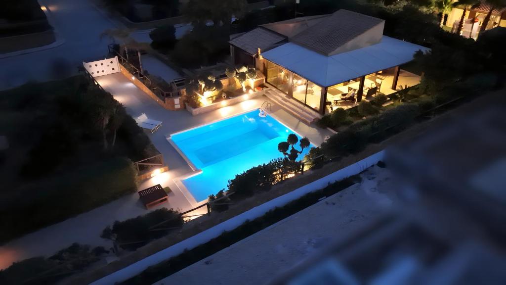 een uitzicht op een zwembad in de nacht bij Villa Antares in Custonaci