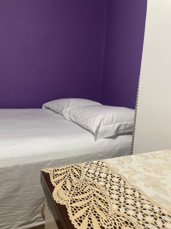 a bedroom with purple walls and a bed with a pillow at Condomínio no coração de São Paulo in São Paulo