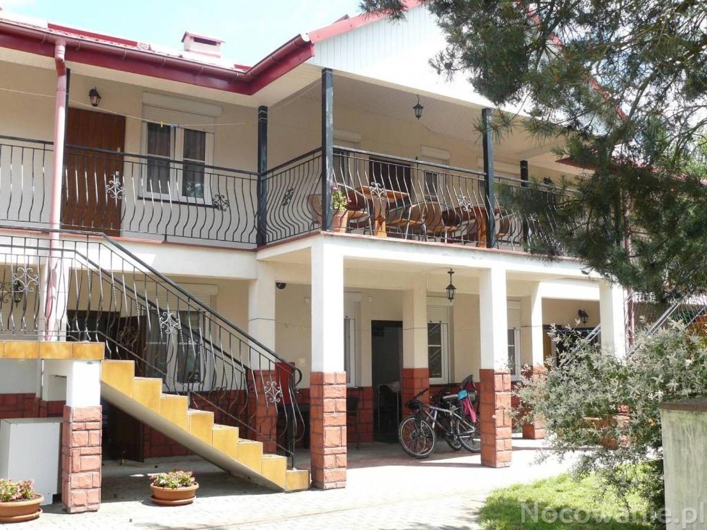 a white house with stairs and a balcony at VILLA BIAŁA in Okuninka