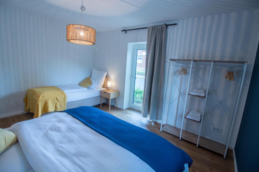 - une chambre bleue avec un lit et une fenêtre dans l'établissement Hygge Homes - 3 Zimmer Apartment, barrierefrei mit Terrasse, à Scharmbeck