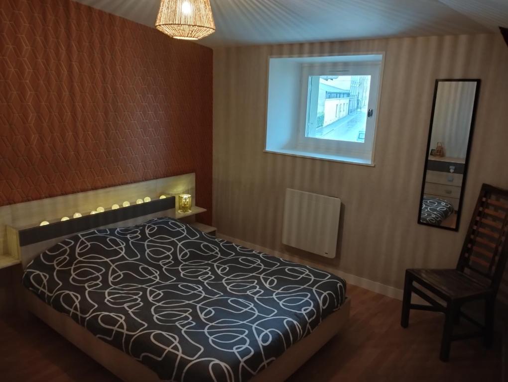 een slaapkamer met een bed, een stoel en een raam bij Pavatou in Aurillac