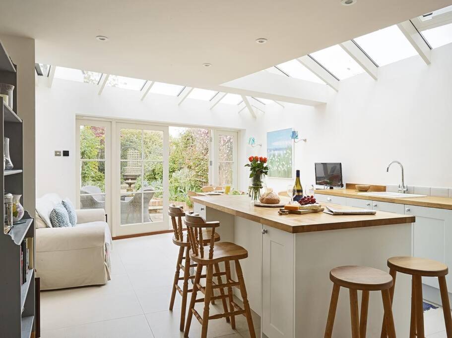 a kitchen with a counter and stools in a room at Northfield End Cottage in Henley on Thames