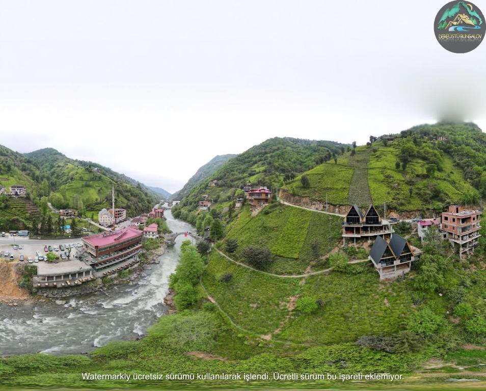 a village on a hill next to a river at Dereüstü ve Gökçe Bungalov - بنغل على ضفاف النهر in Ardeşen