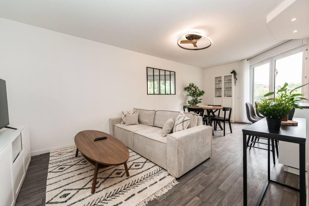 un salon avec un canapé et une table dans l'établissement Appartement T2 Toulouse - 47m2 - Parking gratuit & wifi, à Toulouse