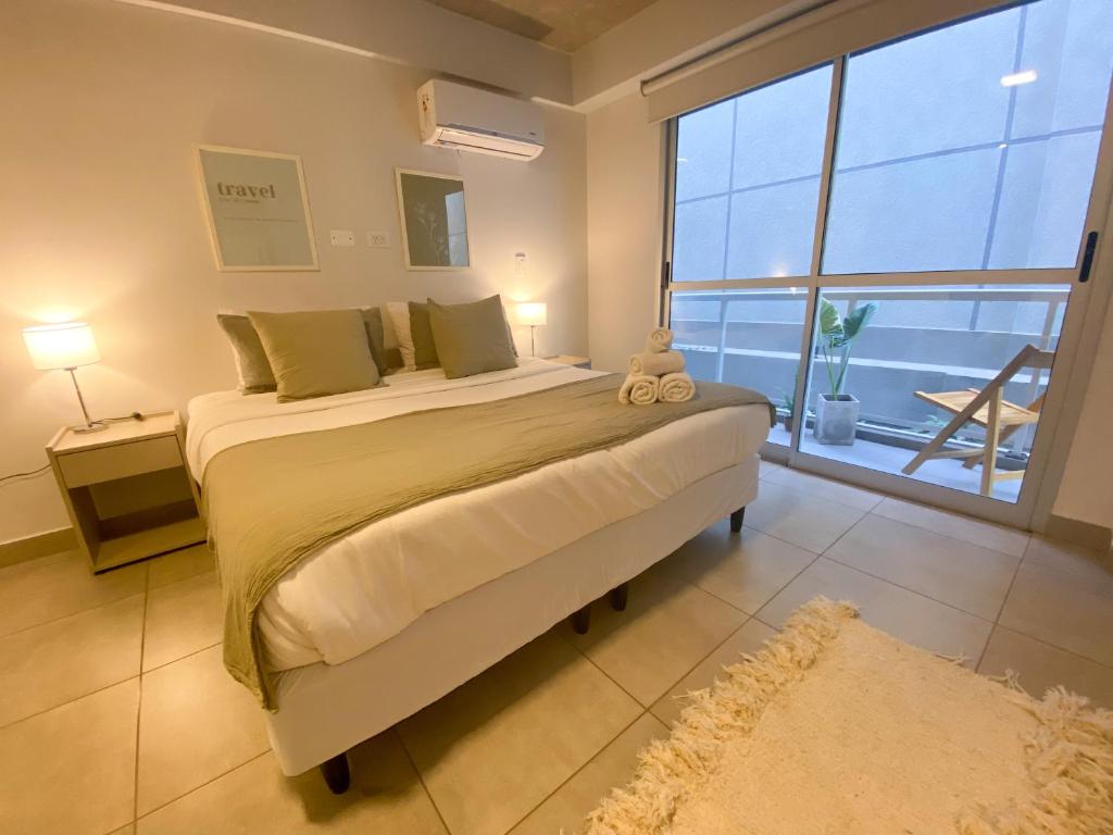 a bedroom with a large bed with a large window at Alfa Suites en el casco histórico de Salta in Salta