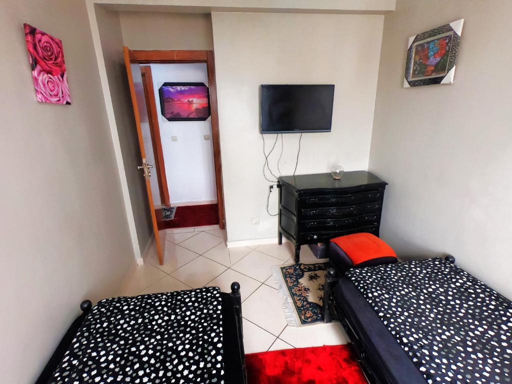 Habitación pequeña con 2 camas y TV. en Cosy apartement close to the AIRPORT en Tánger