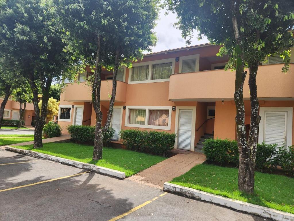 カルダス・ノバスにあるDi Roma Fiori 267 Ap com cozinhaの通りの前に木々が立つ建物