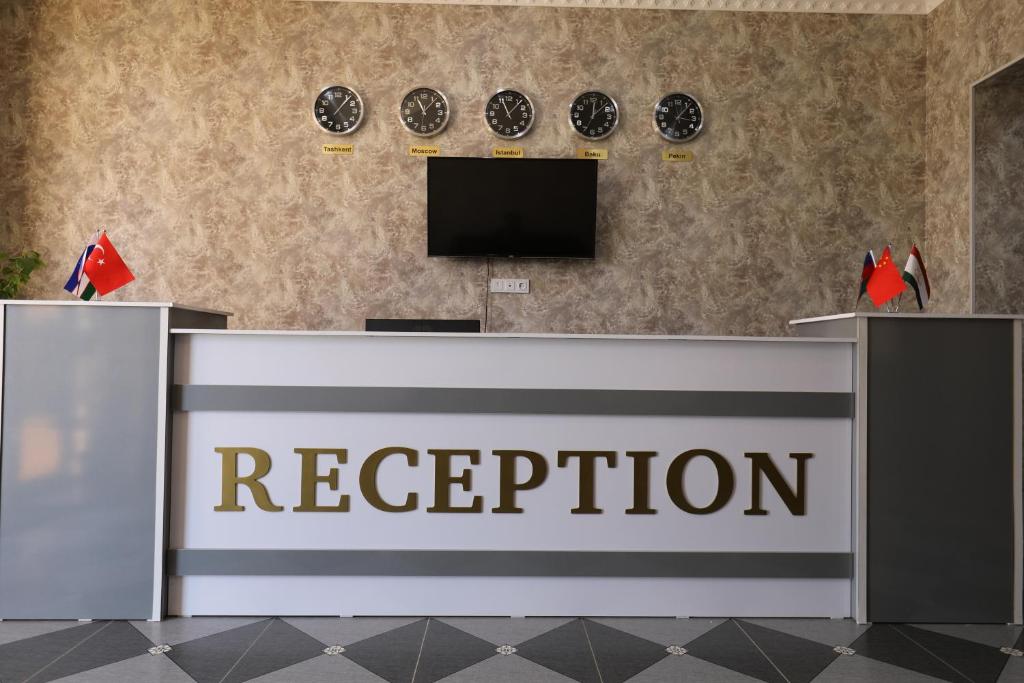 a reception desk with a television on a wall at Boysun palace in Baysun