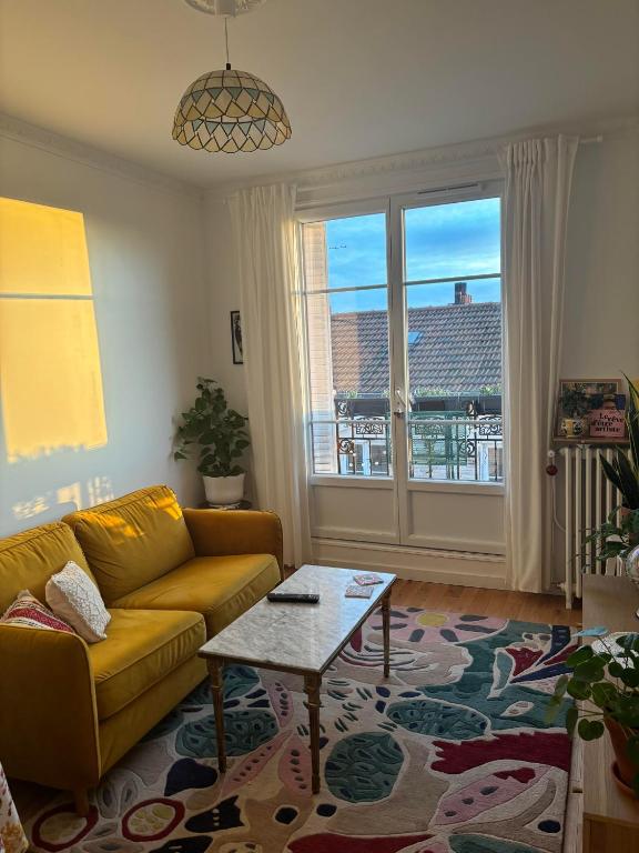un salon avec un canapé et une table dans l'établissement Cute apartment near Paris-JO 24, à Colombes
