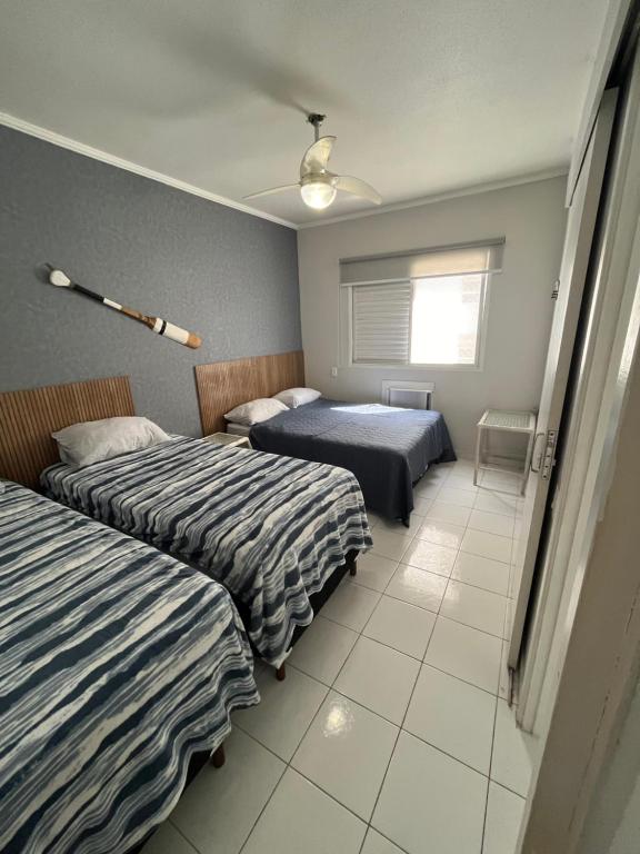 a bedroom with two beds and a window at Guarujá Flat in Guarujá