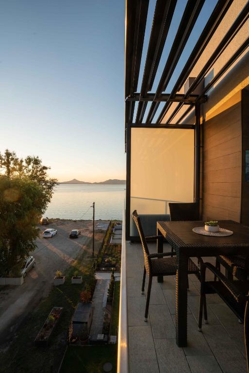 a balcony with a table and a view of the water at Kristall Home Apartment in Fonyód