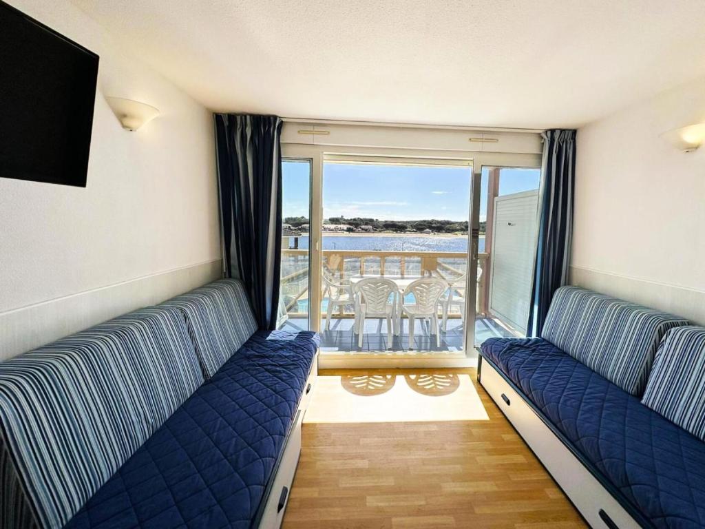 - un salon avec 2 lits et un balcon dans l'établissement Résidence Le Boucanier - 2 Pièces pour 4 Personnes 074, à Vieux-Boucau-les-Bains