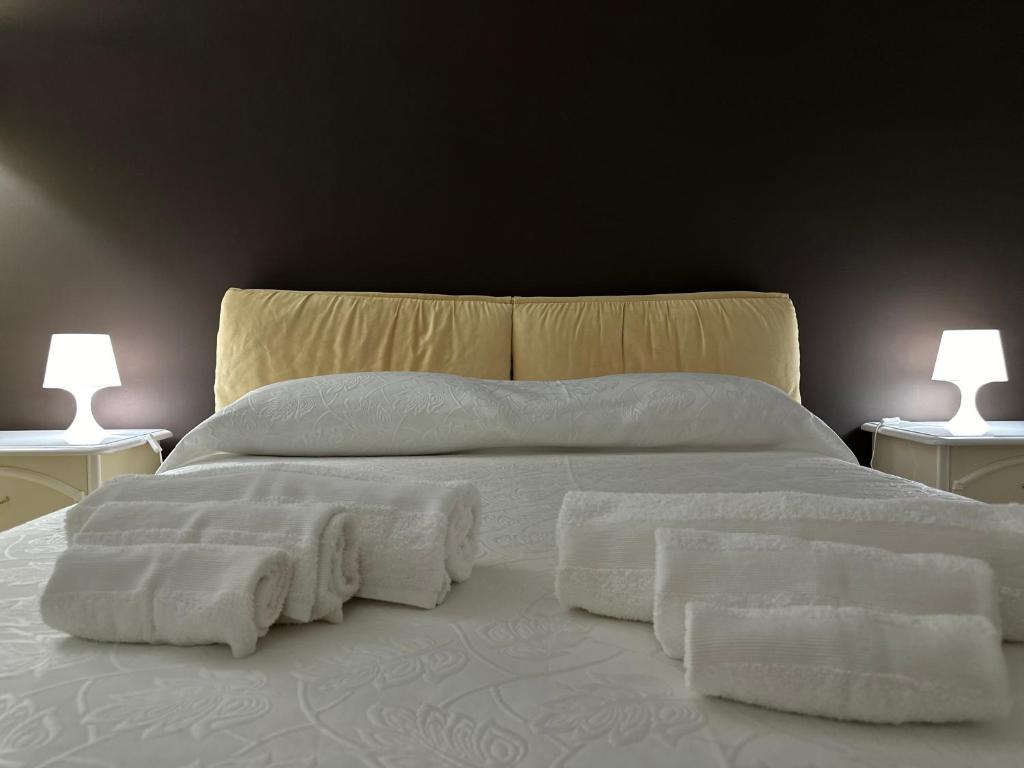 Una cama con mantas blancas y almohadas. en Moonhouse, en Ceglie Messapica