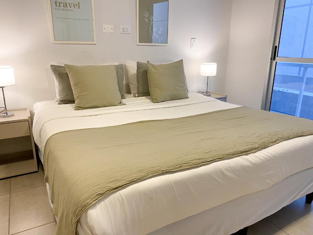 1 cama grande en una habitación con 2 lámparas en Bravo Suites en el casco histórico de Salta, p/ 2. en Salta